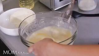 The stepmom and stepdaughter are having fun in the kitchen with each other