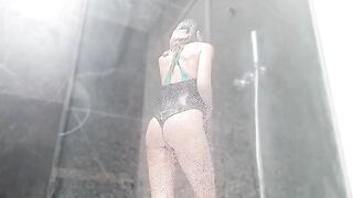 A woman rubs her clitoris until she squirts in the shower