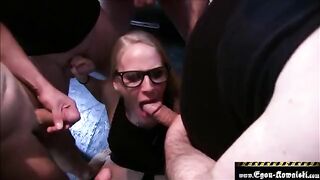 A blonde in glasses gets her mouth filled with cum in an intense bukkake scene