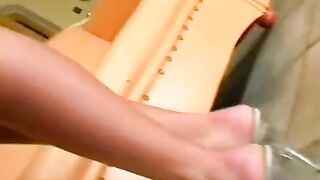 Cute girl caresses herself in a leather chair, showcasing her ass