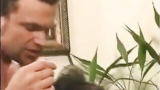 A 40-year-old man playfully squeezes the boobs of a girl in a couch scene