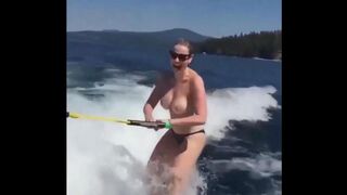 A sexy girl has fun on the water using a ski lift without clothes