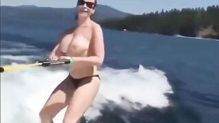 A sexy girl has fun on the water using a ski lift without clothes