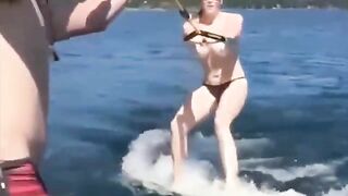 A sexy girl has fun on the water using a ski lift without clothes