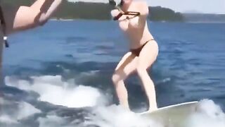 A sexy girl has fun on the water using a ski lift without clothes