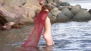 A sexy girl with small boobs has sex on the wet sand