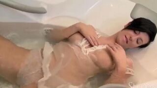 A lonely brunette woman caresses herself in the shower, lost in her desires