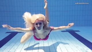 A naked woman is swimming in the pool, creating a sexy splash