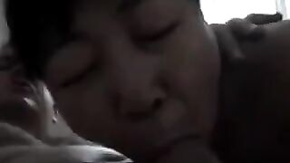 A Chinese woman practices her blowjob skills on him in bed