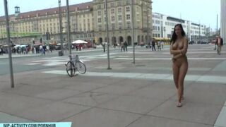 A hot chick walks in the city without any clothes on