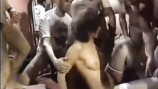 A young whore is having sex with a crowd of guys in a circle
