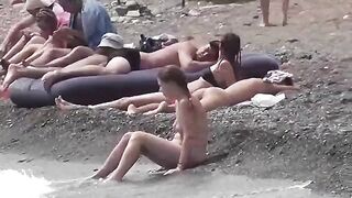 Nudist couple enjoy each other on the beach with no clothes on