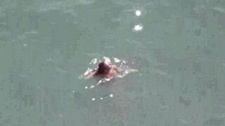 A pair of naturists have fun on the ship in the sea