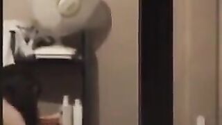 The guy looks at himself in the mirror, not dressed