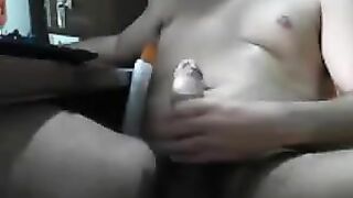 A guy masturbates his cock with his hand while sitting in front of the computer