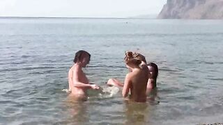 A group of nudists are having fun on the beach without clothes