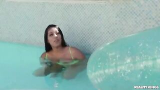 A girl is having swimming lessons in the pool wearing a bikini